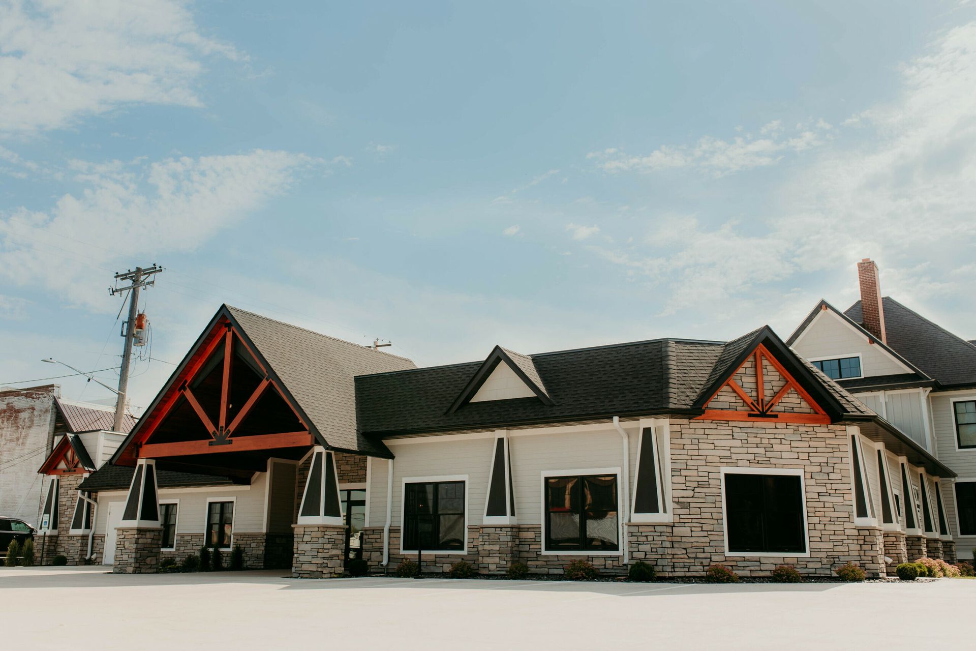 Stone building with black and red gabled roofs under a bright blue sky
