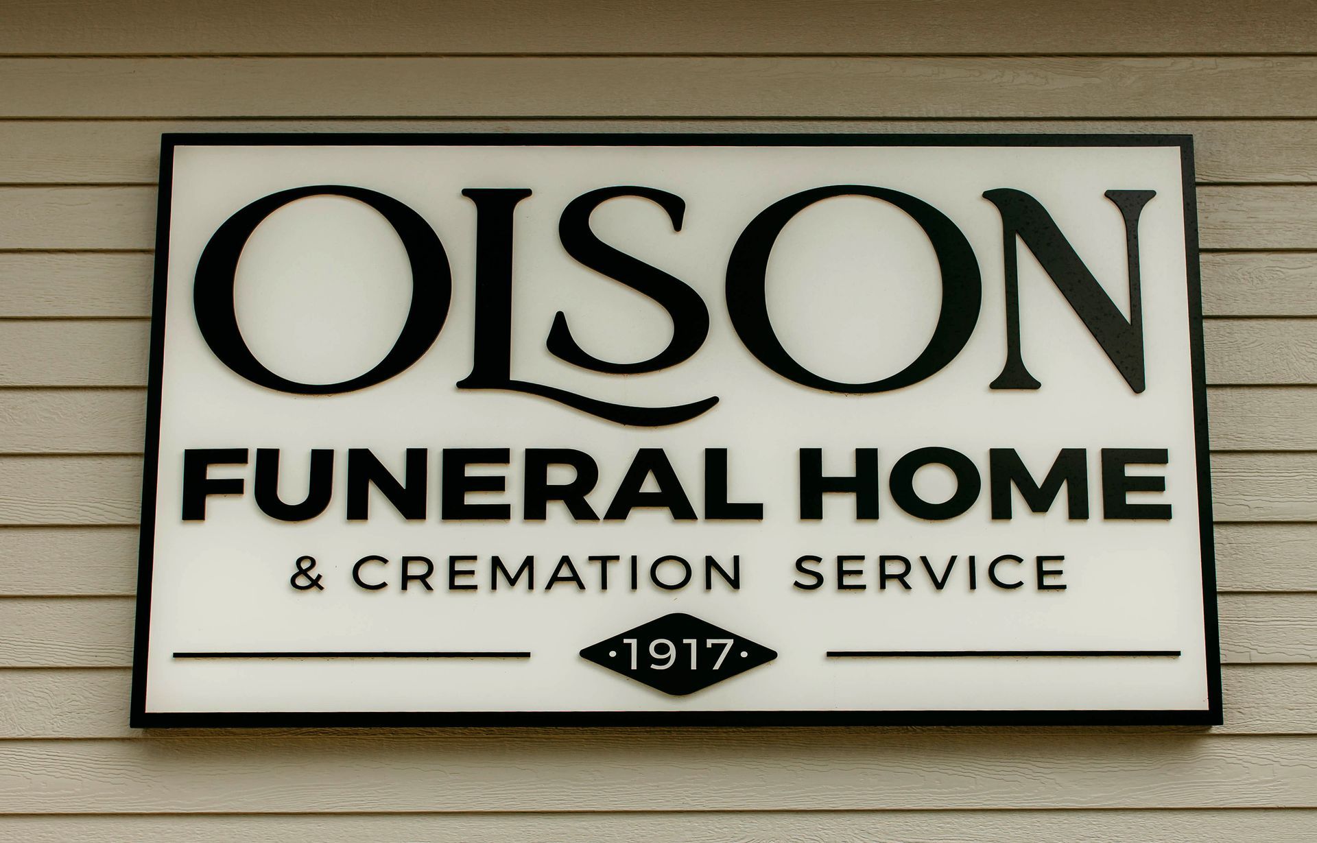 Olson Funeral Home and Cremation Service sign on beige siding