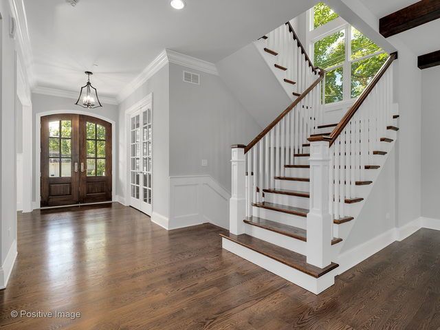An empty hallway with a staircase and a door