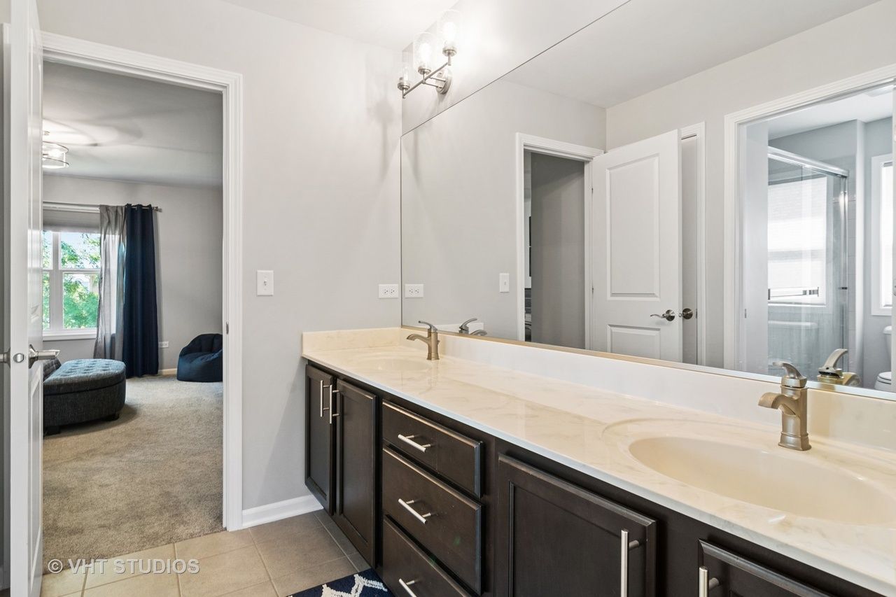 A bathroom with two sinks and a large mirror.