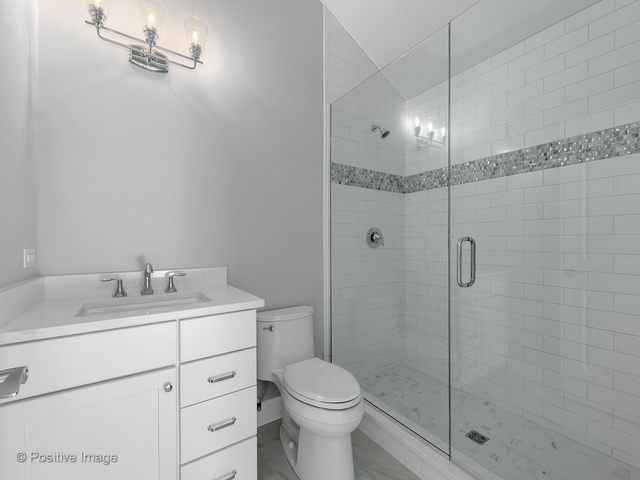 A bathroom with a toilet , sink and walk in shower