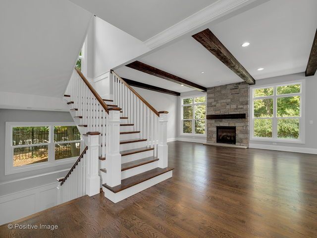 An empty living room with stairs and a fireplace