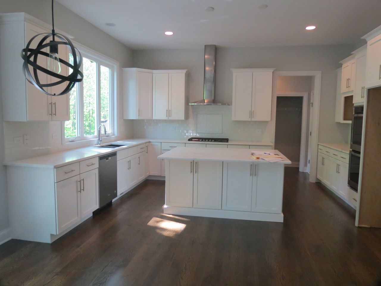 A kitchen with white cabinets and a large island