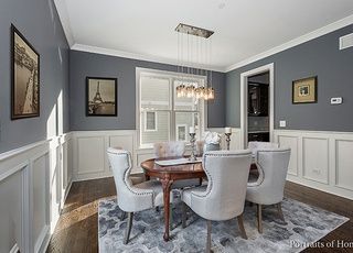 A dining room with a table and chairs and a rug.