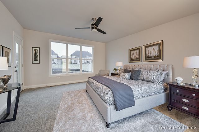 A bedroom with a large bed and a ceiling fan.