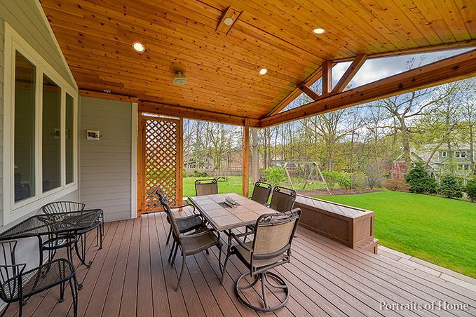 A screened in porch with a table and chairs