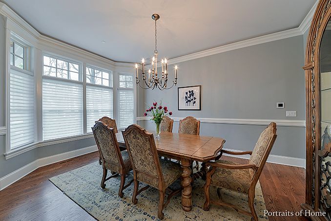 A dining room with a table and chairs and a chandelier.