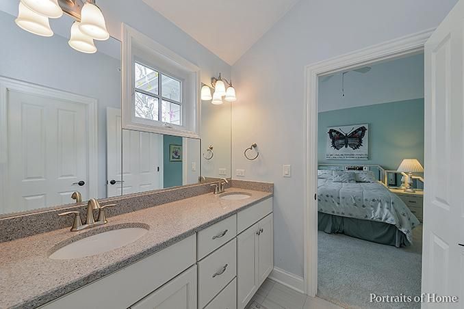 A bathroom with two sinks and a large mirror.