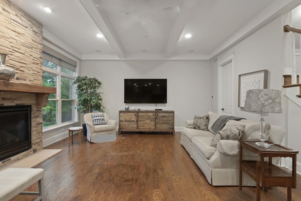 A living room with a couch , fireplace and television.