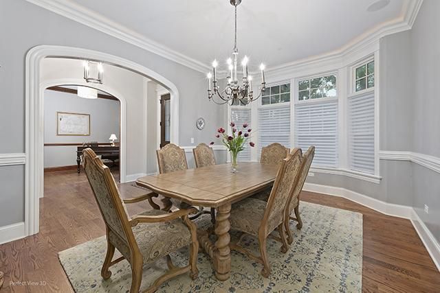 A dining room with a table and chairs and a chandelier.
