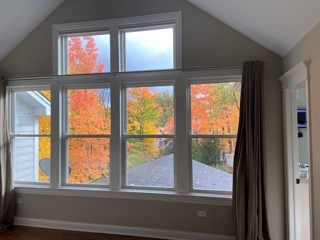 A room with a lot of windows and trees in the background