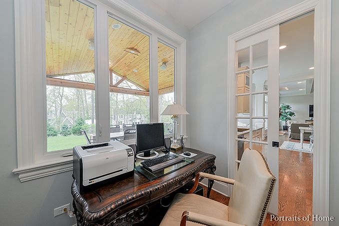 A home office with a desk , chair , computer and printer.