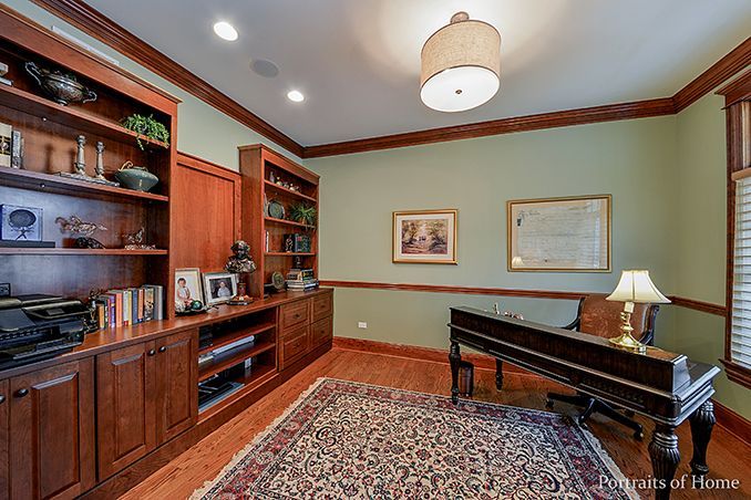 A home office with a piano and a rug