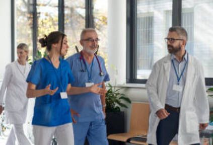 A group of doctors and nurses are walking through a hospital hallway.