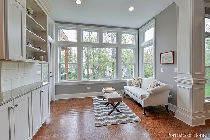 A living room with a couch , rug , and lots of windows.