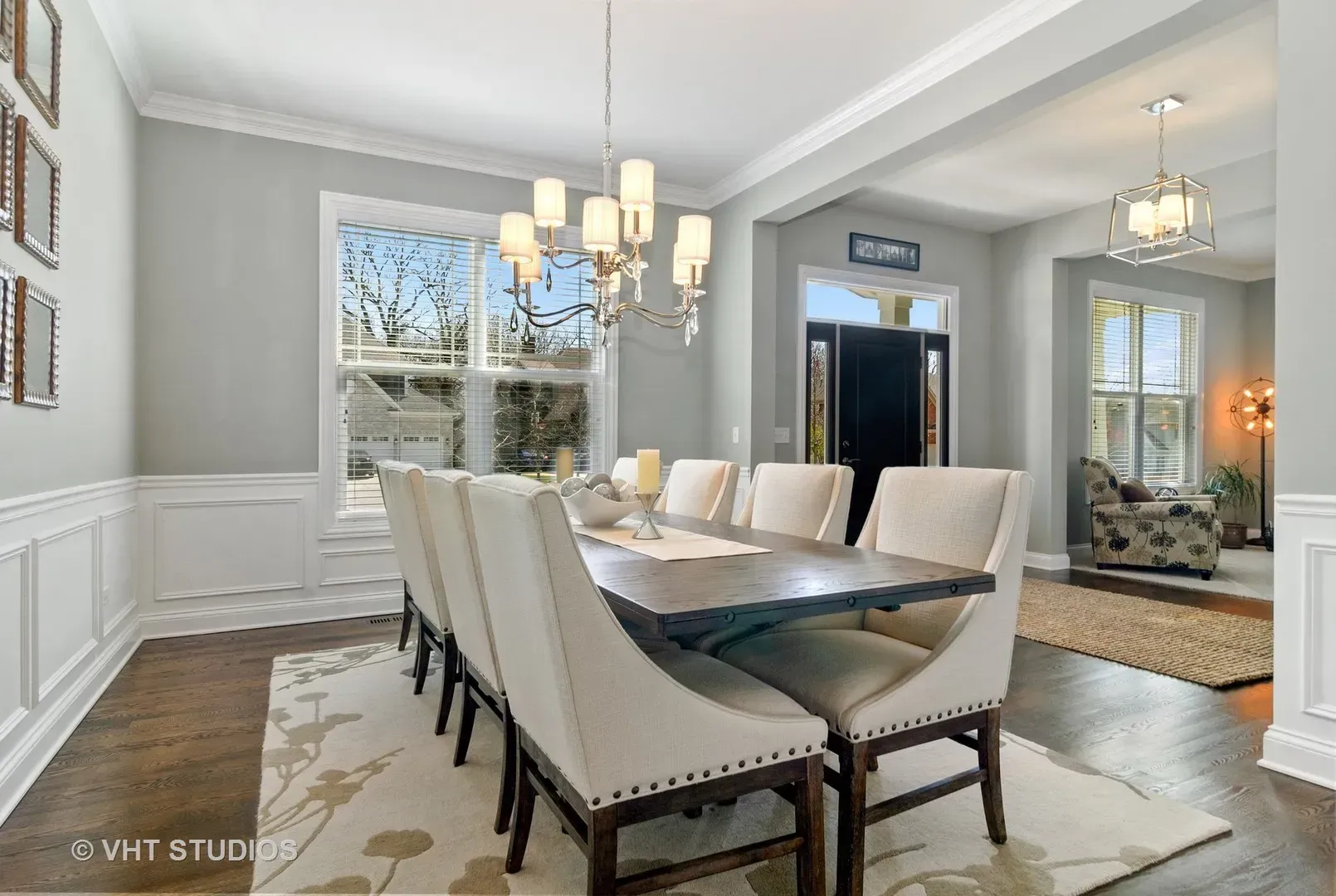 A dining room with a long table and chairs and a chandelier.