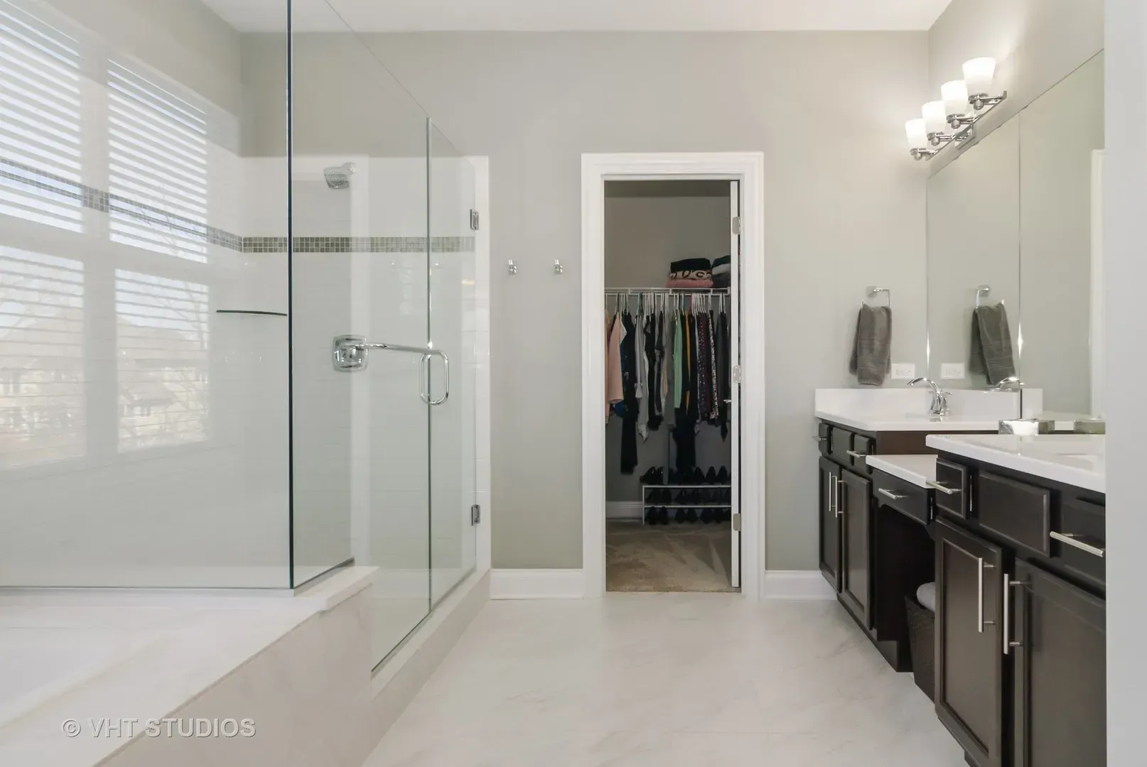 A bathroom with a walk in closet and a walk in shower.