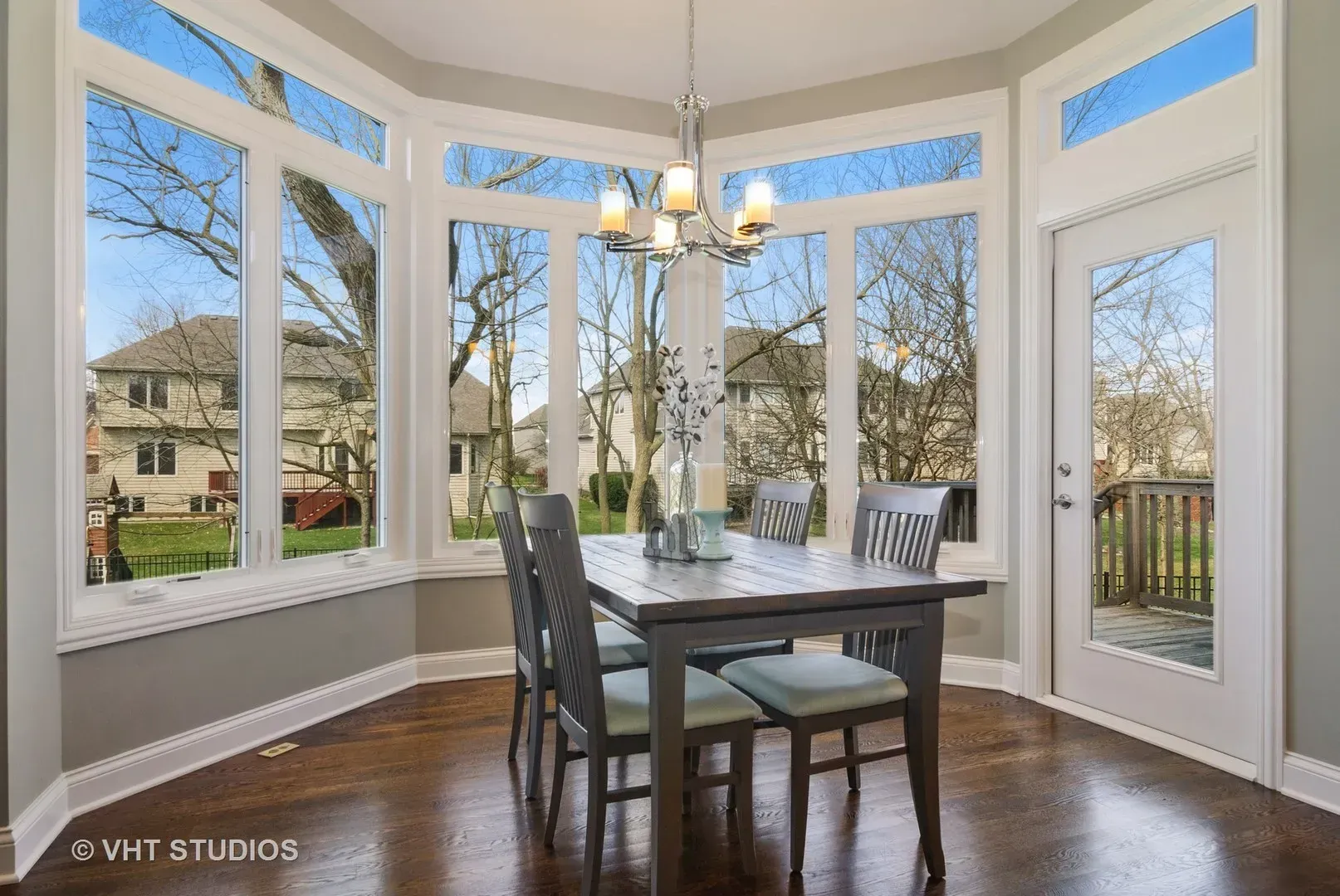A dining room with a table and chairs and a chandelier.