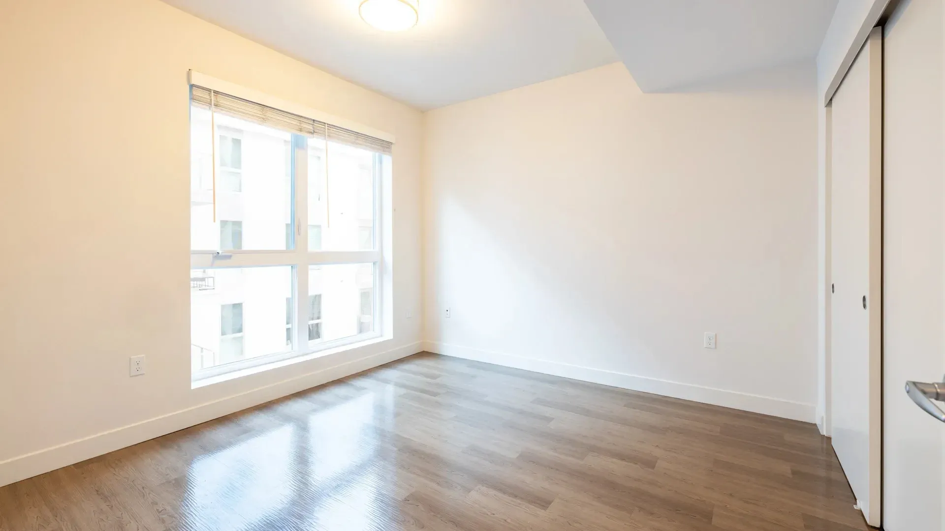 Empty bedroom with a large window and a closet at Next on Sixth Los Angeles