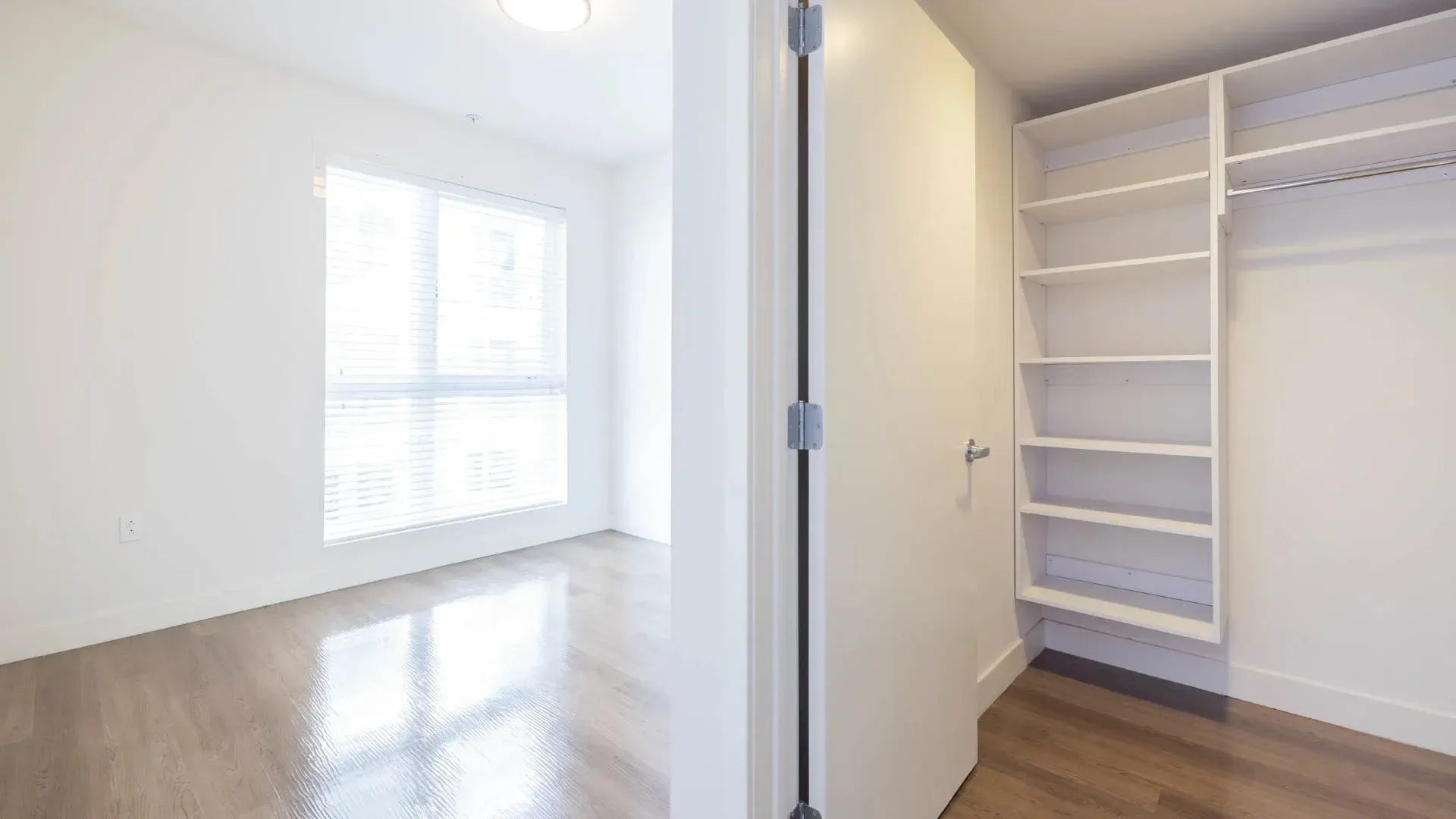 Empty bedroom with large closet and window at Next on Sixth Los Angeles