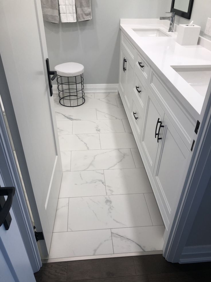 A bathroom with two sinks , a mirror and a stool.