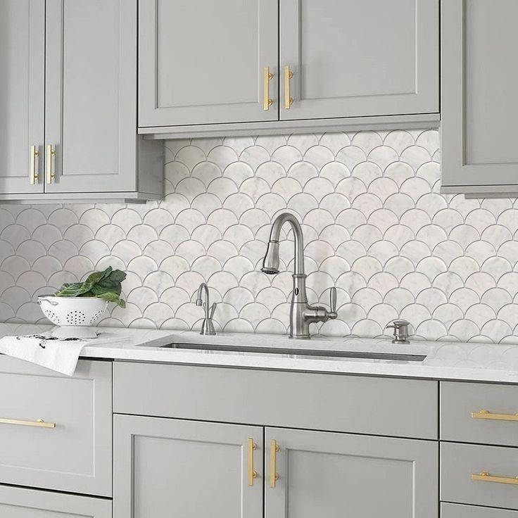 A kitchen with gray cabinets , a sink , and a faucet.