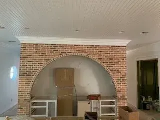 A living room with a brick wall and a white ceiling.