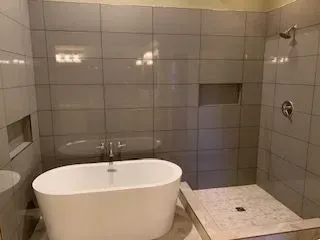 A bathroom with a bathtub and a walk in shower.