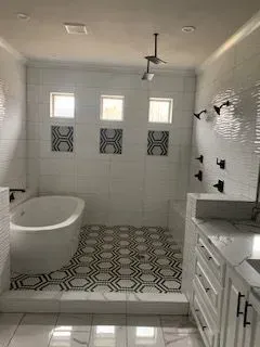 A bathroom with a tub , sink , and shower.