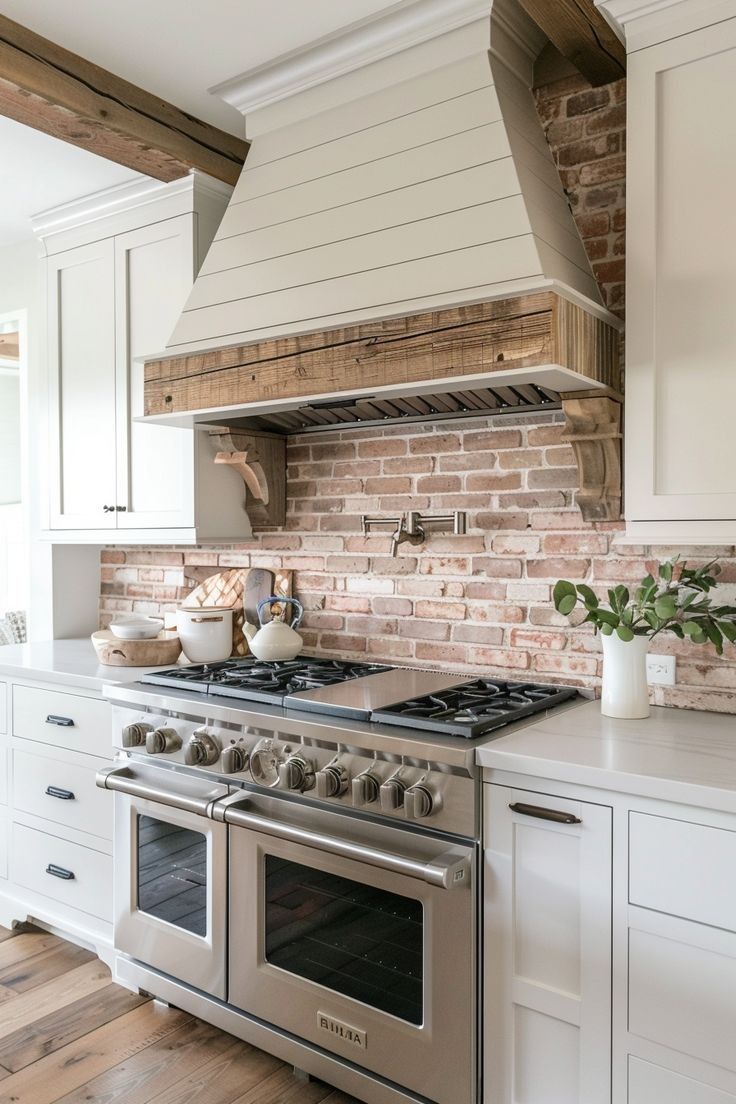 A kitchen with a stove , oven , and brick wall.
