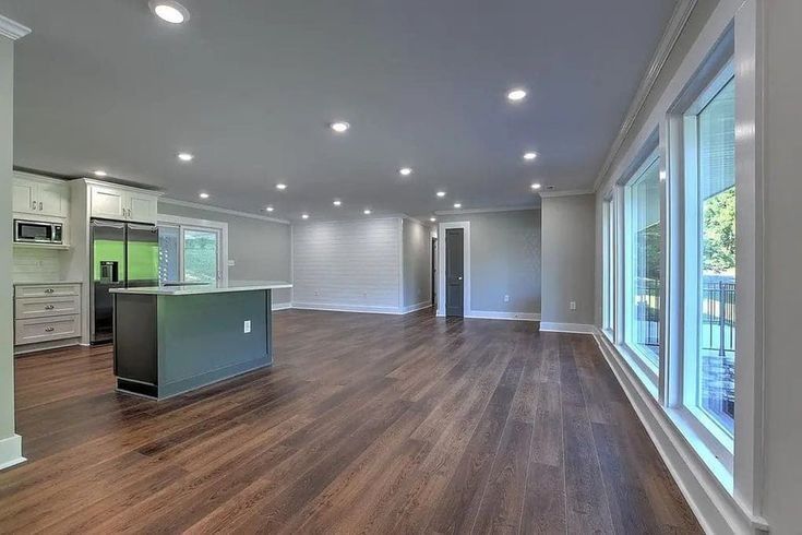 A large empty room with hardwood floors and lots of windows.