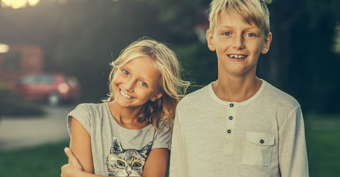 Two Smiling Children Outdoors with A Blurred Sunset Background in Boise, ID