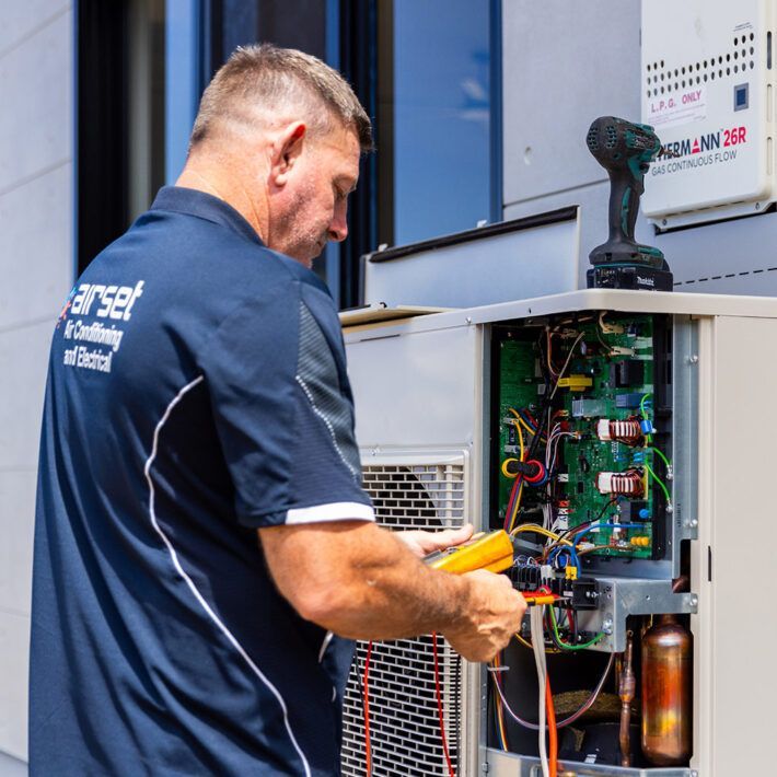 Hvac Technician on a Rooftop, Working on an Air Conditioning Unit, Using Gauges — Airset Air Conditioning in Bellingen, NSW
