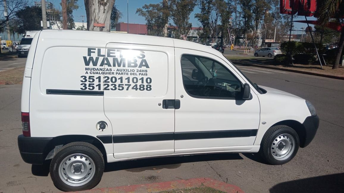 Furgoneta blanca de reparto con el logotipo de la empresa aparcada en una calle a plena luz del día.