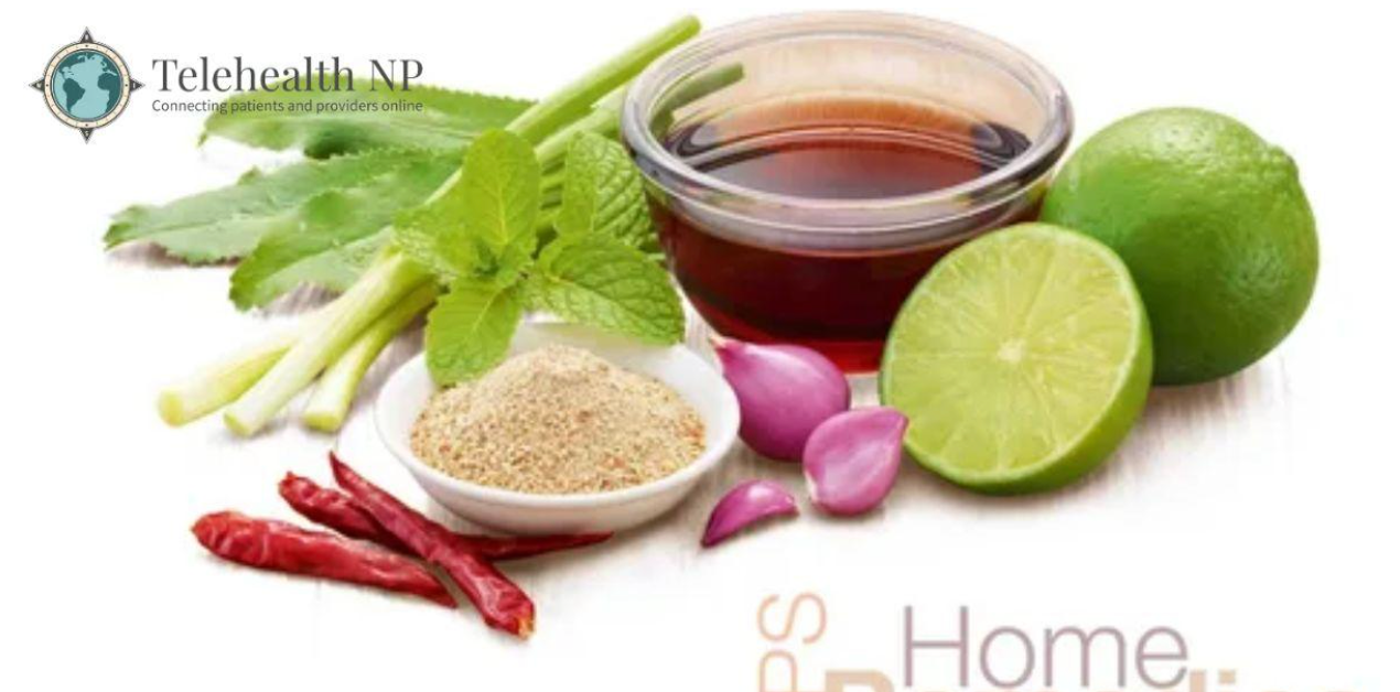 Various herbs and spices, including lime, red peppers, and shallots, next to a bowl of liquid.