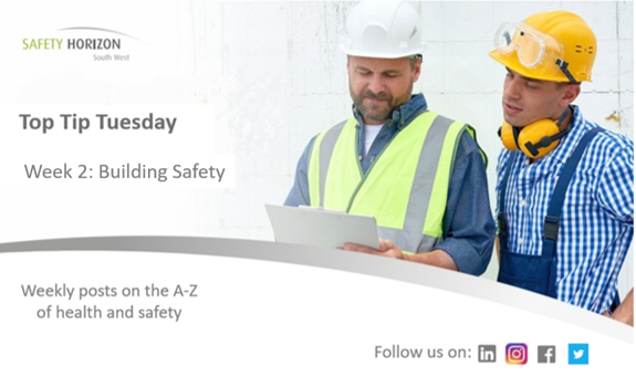 Two men wearing hard hats and safety vests are looking at a piece of paper.