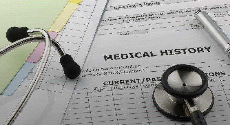 A stethoscope is sitting on top of a medical history form