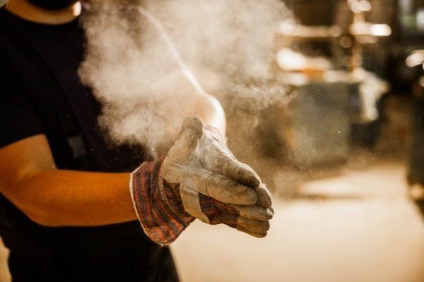 A man wearing a pair of gloves with smoke coming out of them.