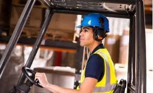 A man is driving a forklift in a warehouse.