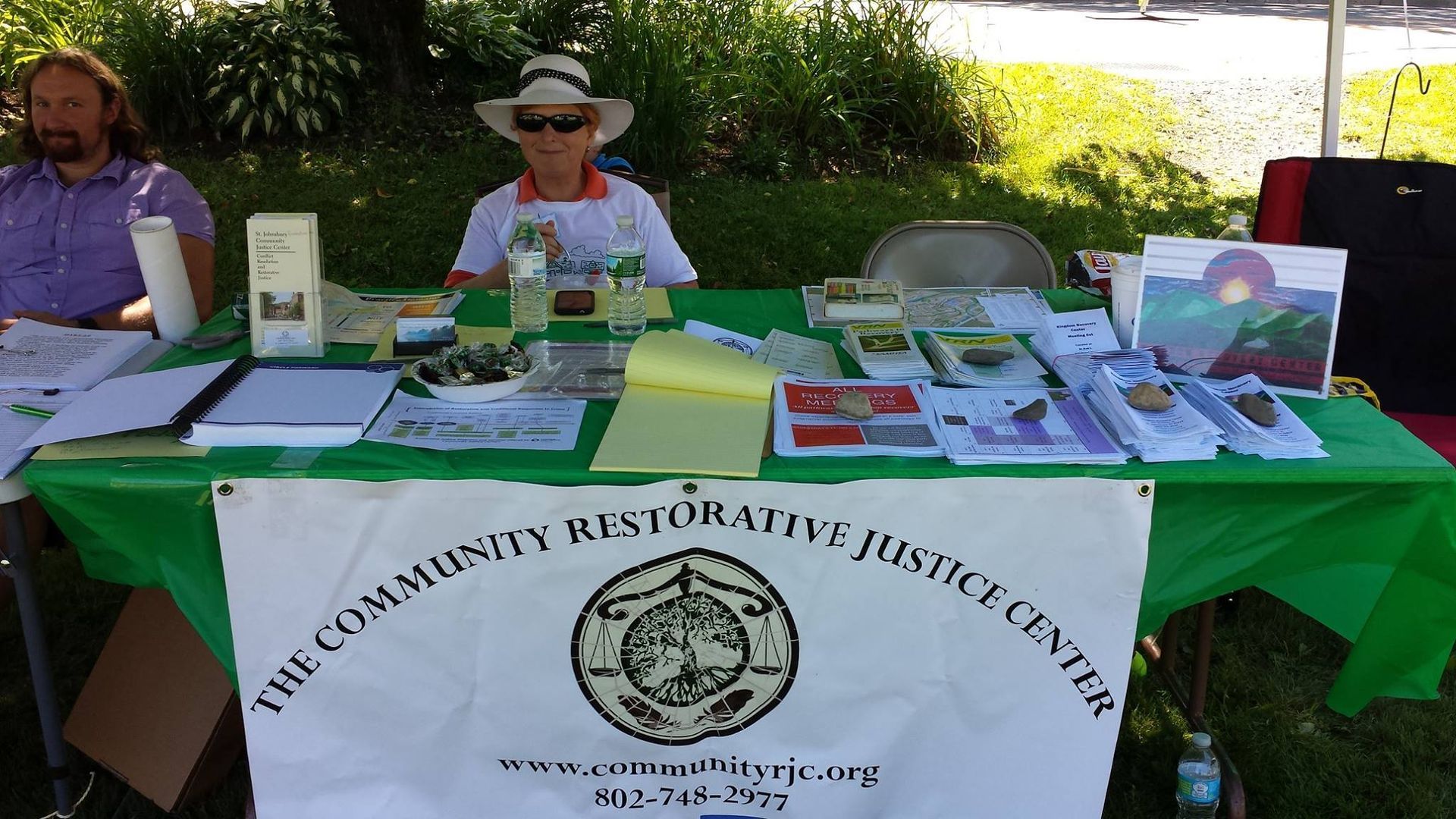 Community Restorative Justice Center: two volunteers sitting at a booth at an event