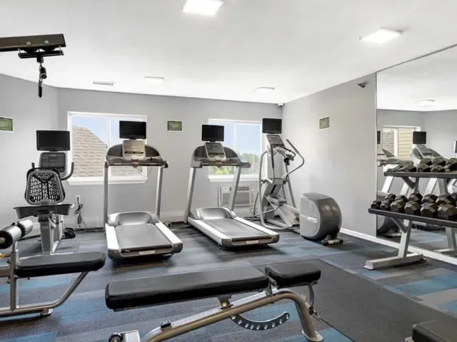 Fitness center with treadmills, elliptical, and free weights.