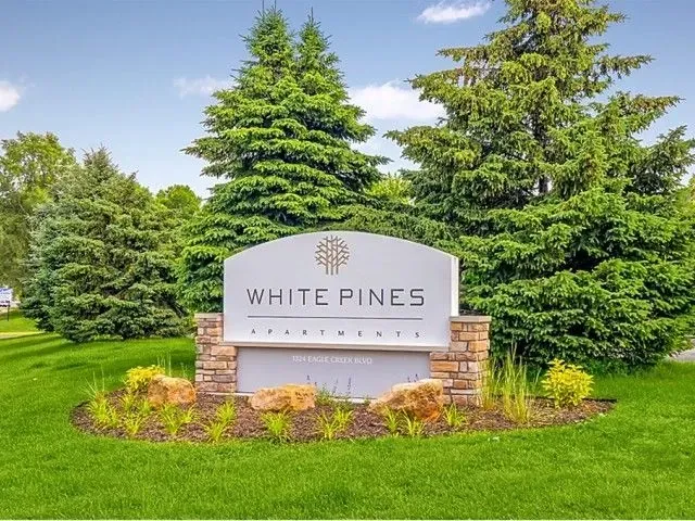 White Pines Apartments monument sign with landscaping.