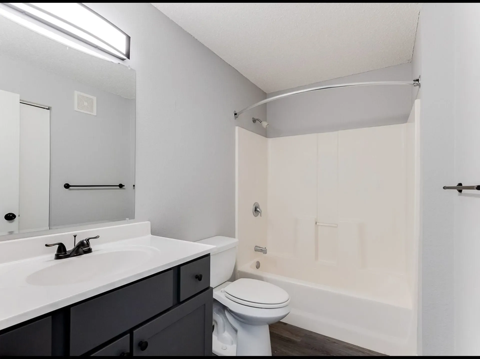 Bathroom with vanity, toilet, and shower/tub combo.