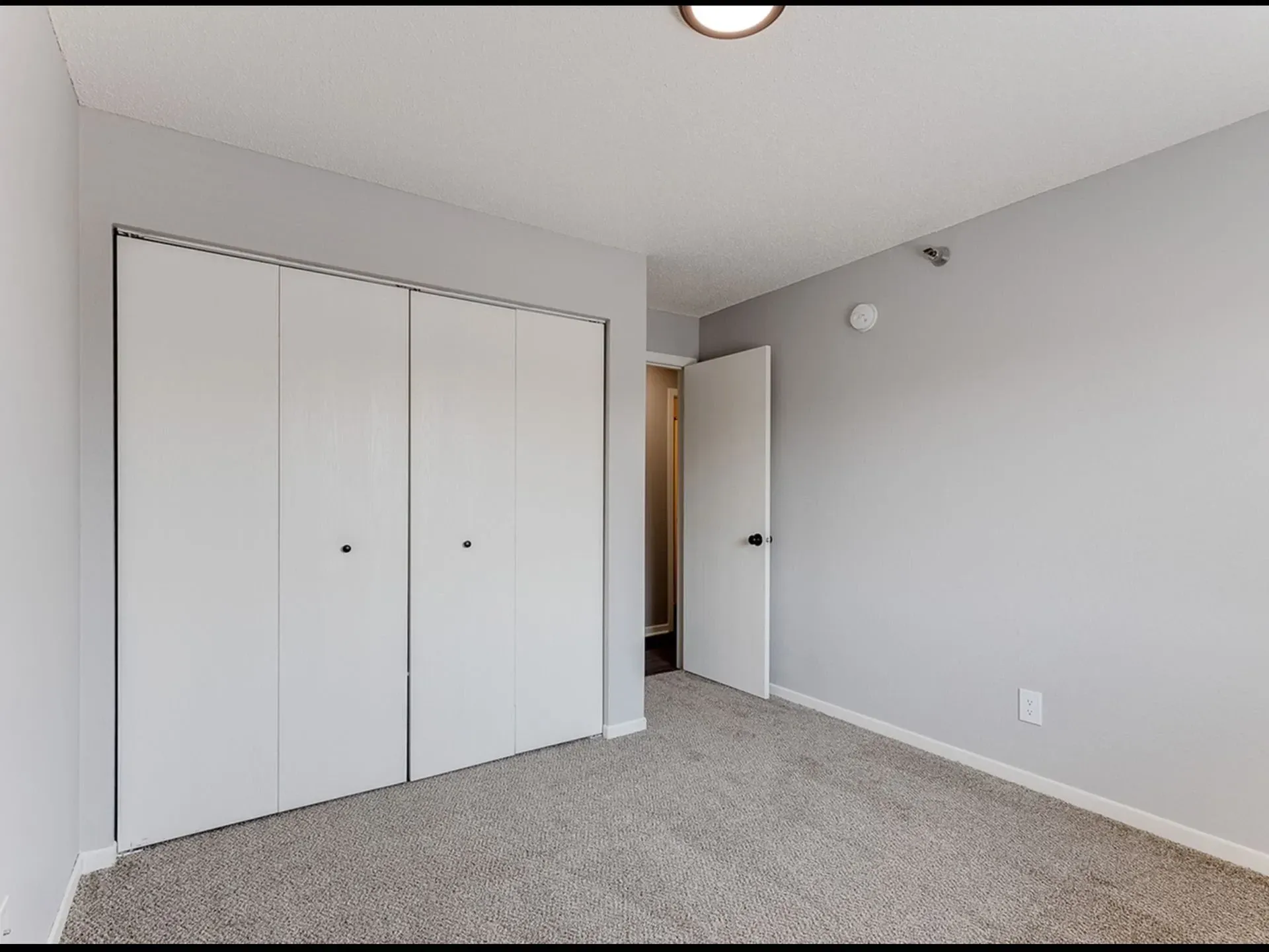 Bedroom with closet doors and carpet.
