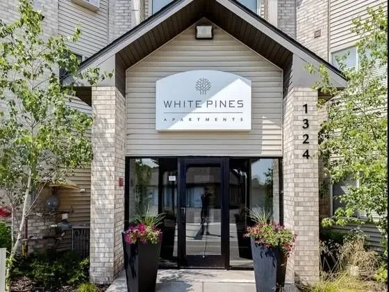 Exterior building entrance of White Pines Apartments with signage and address 1324.