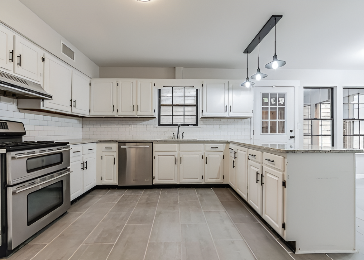 Bright modern white kitchen with stainless steel appliances and tiled floor