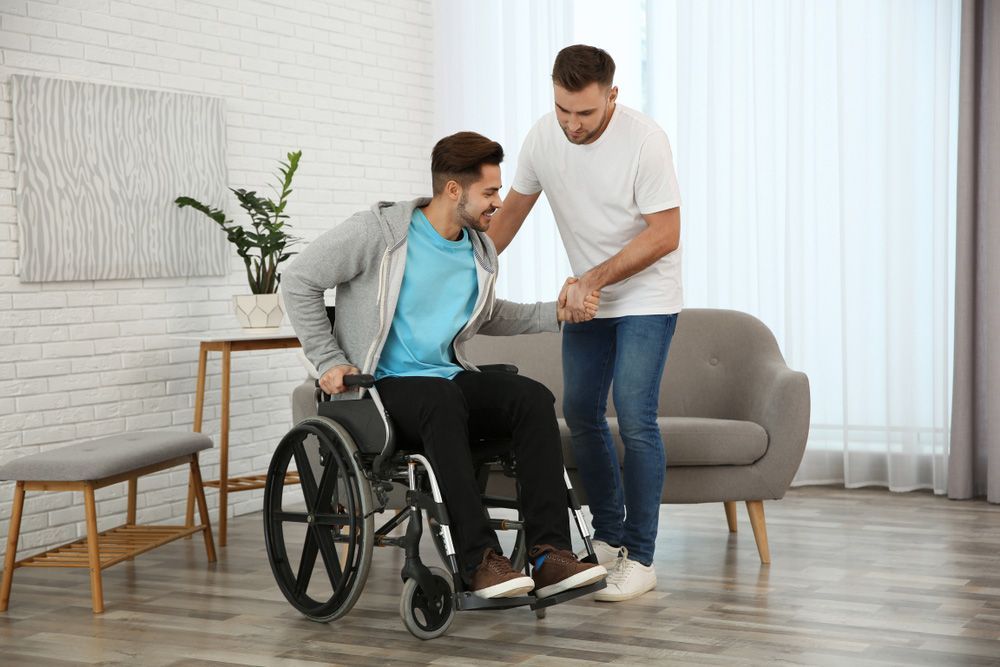 Volunteer Helping Man in Wheelchair at Home — Adaptive Care Pty Ltd In Tarneit, VIC