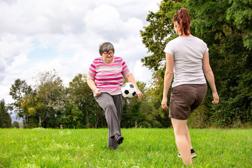 Two Women Are Playing Soccer in a Grassy Field — Adaptive Care Pty Ltd In Tarneit, VIC