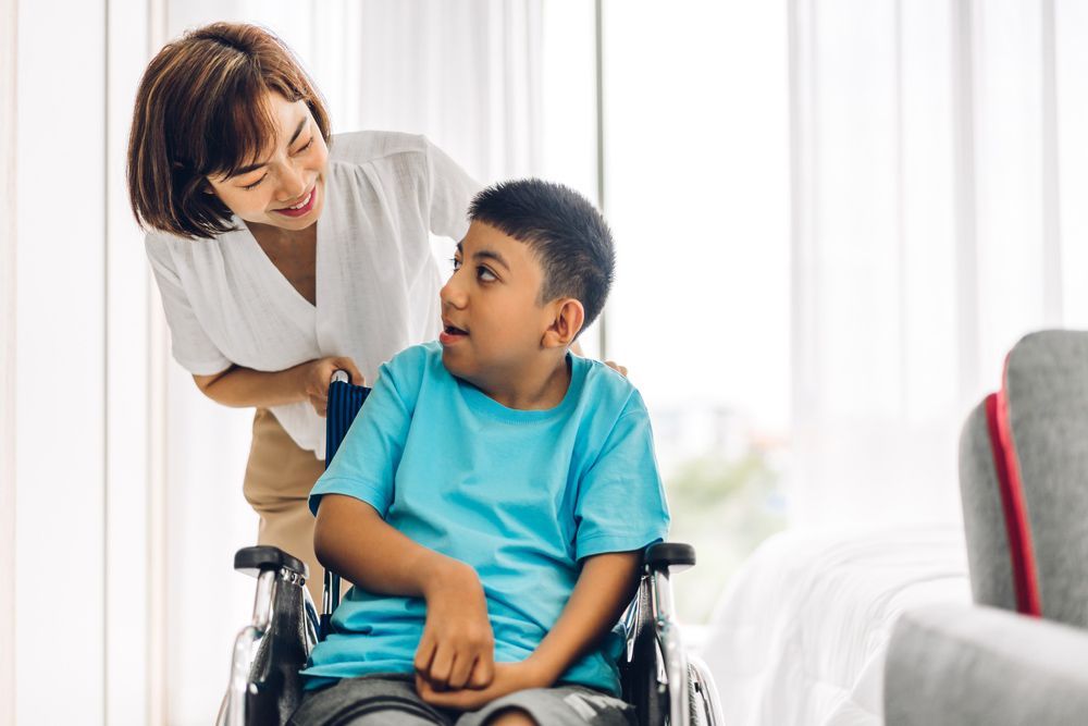 A Person Standing Next to a Child in a Wheelchair — Adaptive Care Pty Ltd In Tarneit, VIC