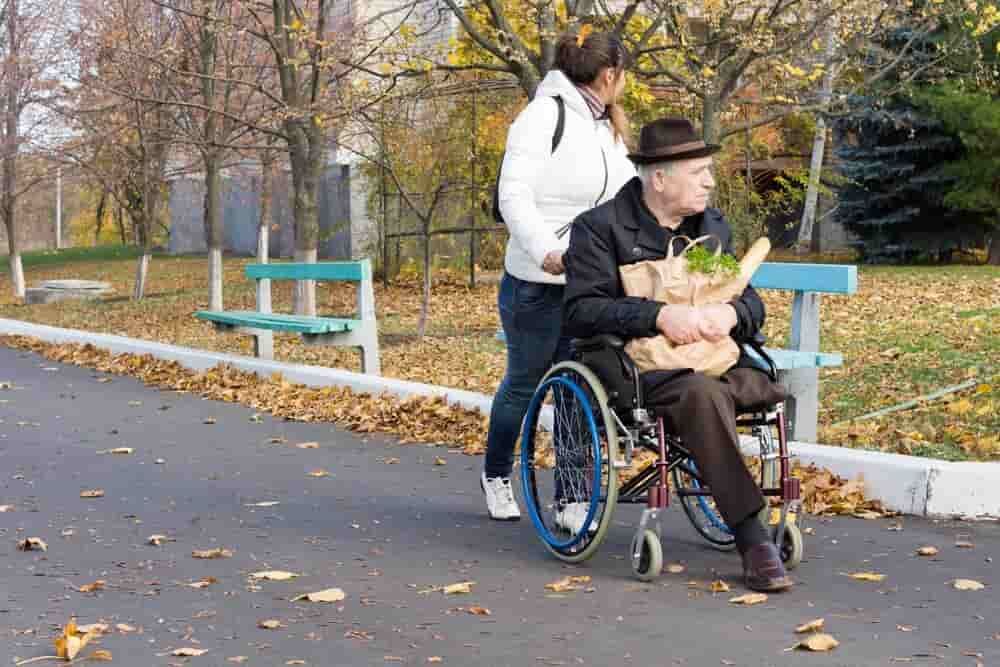 Carer Pushing A Disabled Man With Groceries — Adaptive Care Pty Ltd In Tarneit, VIC